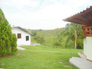 ein Haus mit einem grünen Hof neben einem Gebäude in der Unterkunft Finca familiar privada para el descanso in Puerto Triunfo