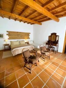 a bedroom with a bed and two chairs and a table at Casal da Serrana in Reguengo Grande