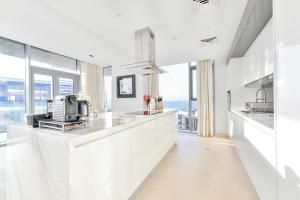 een keuken met witte werkbladen en grote ramen bij Premium 2+1 BR condo in the heart of Bluewaters Island in Dubai