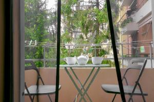 a table with two chairs and cups on a balcony at QUEEN HOME Bianca in Bologna