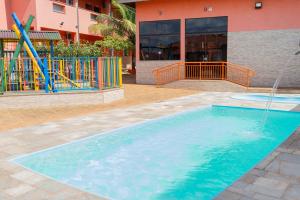 a swimming pool with a water fountain in front of a building at pousada Anna Assumpta in Severínia
