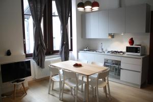 a kitchen with a table and chairs and a kitchen with white cabinets at B&B Mia - Only self check-in in Trento