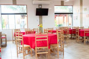 a dining room with tables and chairs and a flat screen tv at pousada Anna Assumpta in Severínia