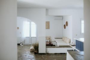 a white living room with a couch and a radiator at The Sunset by KHI in Kithnos