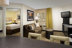 a hotel room with a bed and a living room at Candlewood Suites Richmond - South, an IHG Hotel in Richmond