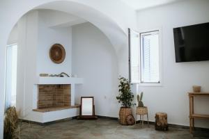 a living room with a fireplace and a tv at The Sunset by KHI in Kithnos