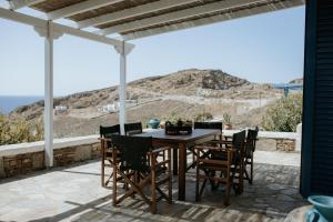 a table and chairs on a patio with a view at The Sunset by KHI in Kithnos