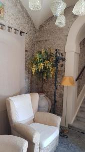 una sala de estar con una silla y un jarrón con flores en B&B Gioiosa e Delia, en Gioiosa Ionica