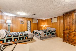 two beds in a room with wooden walls at Pet-Friendly Lincoln Home 1 Mi to Gateway Mall in Lincoln