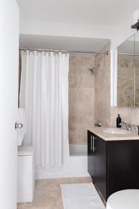 a bathroom with a white shower curtain and a sink at Luxury Private Apt New York City View in New York