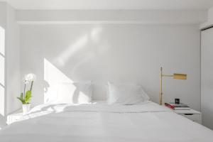 a white bedroom with a white bed with white pillows at Luxury Private Apt New York City View in New York