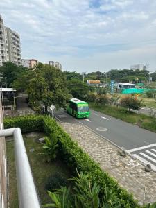 a green bus is driving down a street at Apto en Palmira valle in Palmira