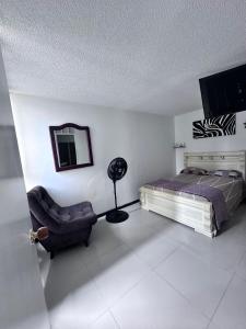 a bedroom with a bed and a chair and a mirror at Apto en Palmira valle in Palmira