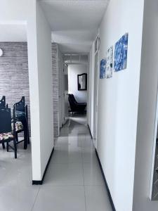 a hallway with white walls and a room with chairs at Apto en Palmira valle in Palmira