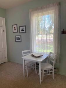 una mesa y sillas blancas en una habitación con ventana en The Mayor's Suite @ The Historic Kanab Inn, en Kanab