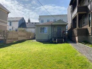 a small house in a yard next to a fence at Quaint Downtown Cottage in Astoria, Oregon