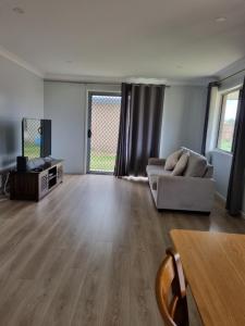 a living room with a couch and a table at Markwell St Villas in Kingaroy