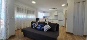 uma sala de estar com um sofá e uma cozinha em Apartamento Caletillas em Candelaria