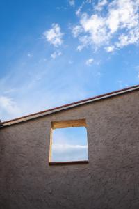 ein Fenster auf der Seite eines Gebäudes mit dem Himmel in der Unterkunft Nou allotjament rural: Cal Teca in Sant Antolí i Vilanova