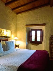 1 dormitorio con cama y ventana en Casal da Serrana, en Reguengo Grande