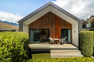 uma casa com um telhado de madeira com uma mesa e cadeiras em Home Away from Home em Queenstown