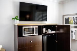 a microwave on top of a cabinet in a kitchen at Little Inn By The Bay Newport Beach Hotel in Newport Beach