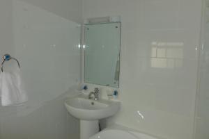 a bathroom with a sink and a toilet and a mirror at Old Bull Inn in Royston