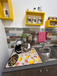 un comptoir de cuisine avec un évier avec des fruits sur une serviette dans l'établissement Ciccio's House, à Palerme 33 autres photos