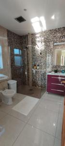 een badkamer met een douche, een toilet en een wastafel bij Mortara Cottage in Ballylongford
