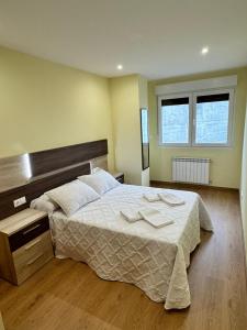 1 dormitorio con 1 cama con 2 toallas en Cortiñas, en Vilalba