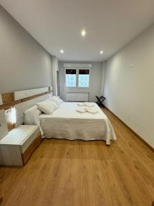 1 dormitorio con 2 camas y suelo de madera en Cortiñas, en Vilalba