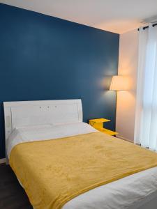 a bedroom with a bed with a blue wall at sacha's house ,à coté du RER,val d'europe,Paris-Disney . in Bussy-Saint-Georges