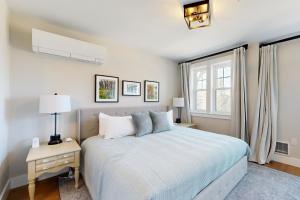 a white bedroom with a bed and a window at Mountain Sunset Villa in Waterville Valley