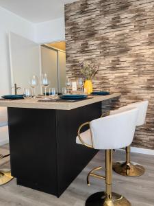 a kitchen with a black island with a white chair at sacha's house ,à coté du RER,val d'europe,Paris-Disney . in Bussy-Saint-Georges