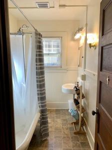 uma casa de banho com um chuveiro, uma banheira e um lavatório. em Historic Downtown Riverview Flat, No. 2 em Astoria
