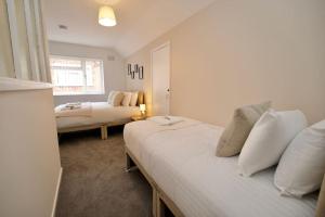 1 dormitorio con 2 camas y sofá en Hall Lane House - Stunning 4Bed 5 mins Walk to Coventry Hospital, Must See!, en Coventry