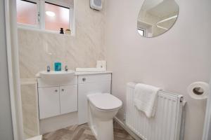 Baño blanco con aseo y lavamanos en Hall Lane House - Stunning 4Bed 5 mins Walk to Coventry Hospital, Must See!, en Coventry