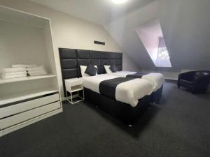 1 dormitorio con 1 cama grande y 1 silla en RYAN I AIR I BNB - 102 Mill Street - Free Parking, en Liverpool