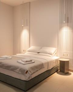 Dormitorio blanco con cama y mesa en Harmony Luxury Apartment, en Ierápetra