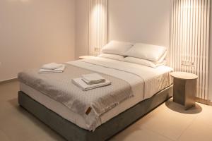 1 dormitorio con 1 cama con 2 toallas en Harmony Luxury Apartment, en Ierápetra