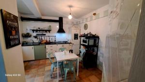 a kitchen with a table and chairs in a room at Carmen Guest House in Benalmádena