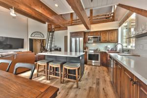 a kitchen with wooden cabinets and a kitchen island with bar stools at Enjoy High End Appliances, Private Hot Tub & Amazing Views at Deer Valley Black Bear Penthouse B! in Park City