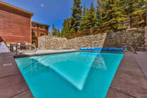 a swimming pool in a backyard with a brick wall at Enjoy High End Appliances, Private Hot Tub & Amazing Views at Deer Valley Black Bear Penthouse B! in Park City