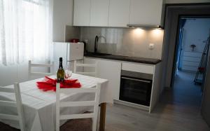 eine Küche mit einem Tisch und einer Flasche Wein darauf in der Unterkunft Apartments Josipa in Primošten