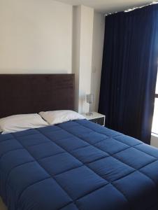 a bedroom with a blue bed and a window at ALPHA69 in Cajamarca
