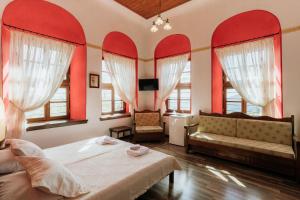 ポルタリアにあるArchontiko Kantartziの赤い壁のベッドルーム1室、ベッド1台、ソファが備わります。