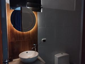 a bathroom with a sink and a mirror and a toilet at ALPHA69 in Cajamarca