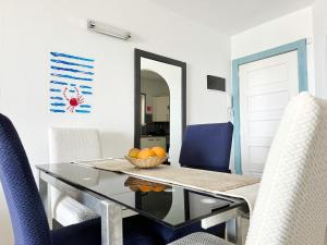 a dining room with a glass table and blue chairs at Relaxing Ocean View, Spacious Art Apartment With Large Terrace, Near Best Costa Adeje Beaches in Adeje +37 photos