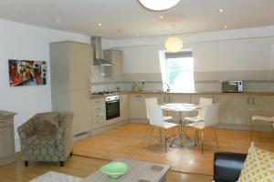 a kitchen and living room with a table and chairs at Old Bull Inn in Royston