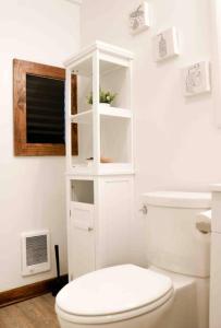 a white bathroom with a toilet and a window at The New Luxury Cabin PetFriendly Pocono Summit in Pocono Summit